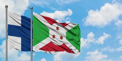 Finland and Burundi flag waving in the wind against white cloudy blue sky together. Diplomacy...