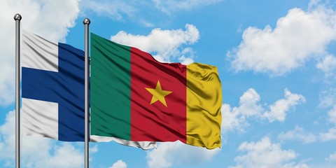Finland and Cameroon flag waving in the wind against white cloudy blue sky together. Diplomacy concept, international relations.