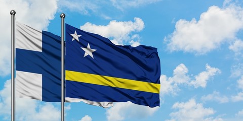Finland and Curacao flag waving in the wind against white cloudy blue sky together. Diplomacy concept, international relations.