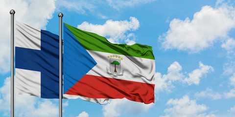 Finland and Equatorial Guinea flag waving in the wind against white cloudy blue sky together. Diplomacy concept, international relations.