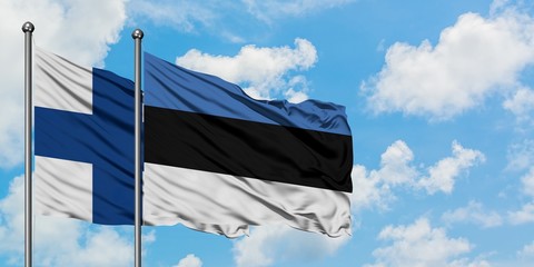Finland and Estonia flag waving in the wind against white cloudy blue sky together. Diplomacy...