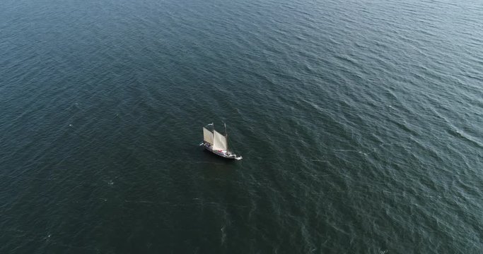 Single sail ship out in the sea - aerial drone shot