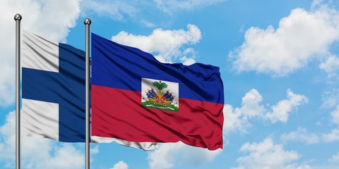 Finland and Haiti flag waving in the wind against white cloudy blue sky together. Diplomacy concept, international relations.