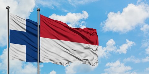 Finland and Indonesia flag waving in the wind against white cloudy blue sky together. Diplomacy concept, international relations.