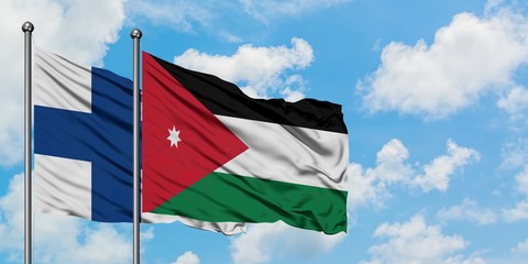 Finland and Jordan flag waving in the wind against white cloudy blue sky together. Diplomacy concept, international relations.
