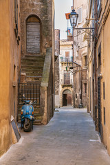 Fototapeta na wymiar Tipico vicolo italiano con scooter Vespa parcheggiato