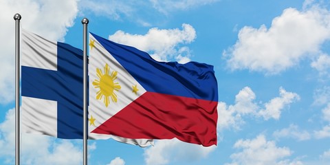 Finland and Philippines flag waving in the wind against white cloudy blue sky together. Diplomacy concept, international relations.