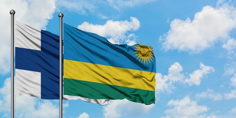 Finland and Rwanda flag waving in the wind against white cloudy blue sky together. Diplomacy concept, international relations.