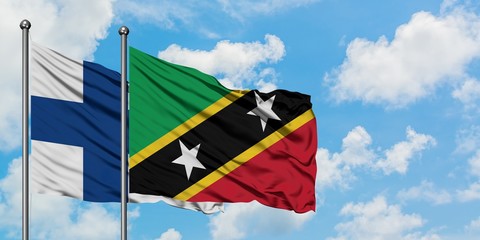 Finland and Saint Kitts And Nevis flag waving in the wind against white cloudy blue sky together. Diplomacy concept, international relations.