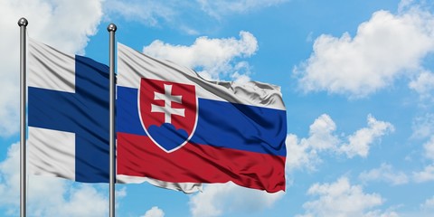 Finland and Slovakia flag waving in the wind against white cloudy blue sky together. Diplomacy concept, international relations.