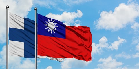 Finland and Taiwan flag waving in the wind against white cloudy blue sky together. Diplomacy concept, international relations.