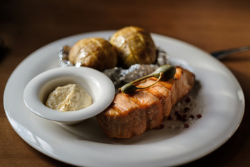 grilled salmon steak and baked potatoes with sauce