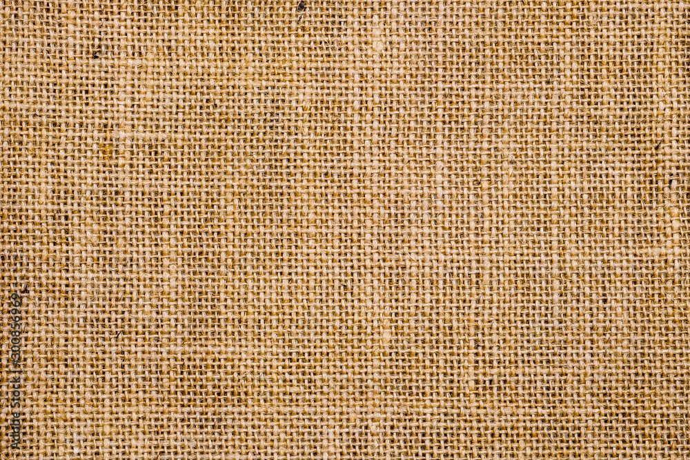 Wall mural Rough hessian background with flecks of varying colors of beige and brown. with copy space. office desk concept, Hessian sackcloth burlap woven texture background.