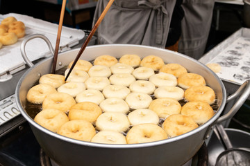 Deep frying doughnuts in hot oil. Made of fresh ingredients tasty.