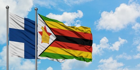 Finland and Zimbabwe flag waving in the wind against white cloudy blue sky together. Diplomacy concept, international relations.