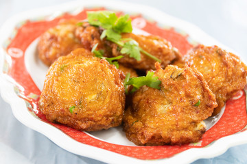 Fried crabs-paste balls in dish usually served with dipping plum sauce and sliced of fresh cucumber with chili.