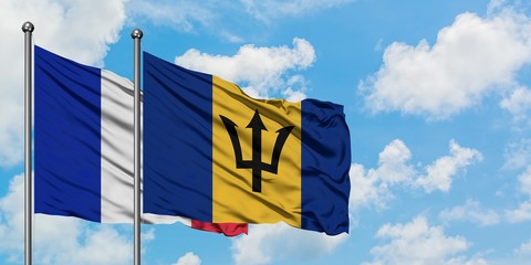 France and Barbados flag waving in the wind against white cloudy blue sky together. Diplomacy concept, international relations.