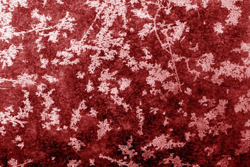 Abstract frost pattern on glass in red tone.
