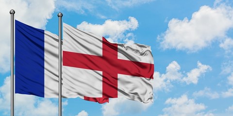 France and England flag waving in the wind against white cloudy blue sky together. Diplomacy concept, international relations.