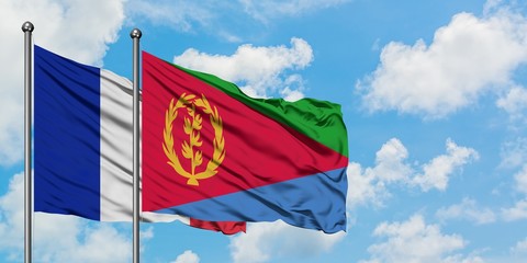 France and Eritrea flag waving in the wind against white cloudy blue sky together. Diplomacy concept, international relations.
