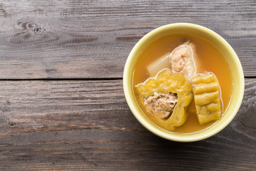 Bitter gourd soup with pork ribs in bowl on wood table