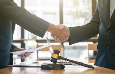 Business people shake hands with a lawyer after signing the contract.