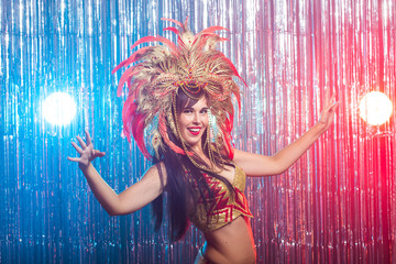 Carnival, dancer and holiday concept - Portrait of a sexy female in a colorful sumptuous carnival feather suit. Nightlife of female dancer