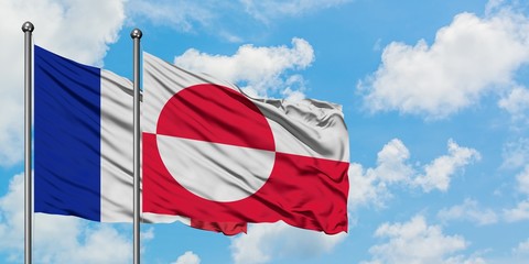 France and Greenland flag waving in the wind against white cloudy blue sky together. Diplomacy concept, international relations.