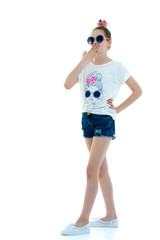 Portrait of a cute little girl covering her mouth with hands, is