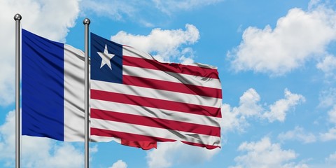 France and Liberia flag waving in the wind against white cloudy blue sky together. Diplomacy concept, international relations.
