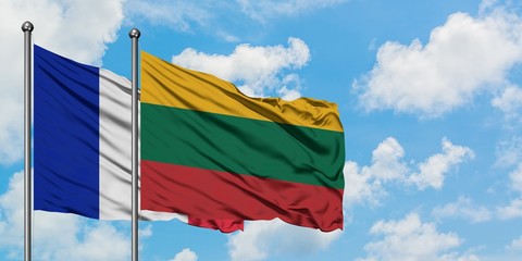 France and Lithuania flag waving in the wind against white cloudy blue sky together. Diplomacy concept, international relations.