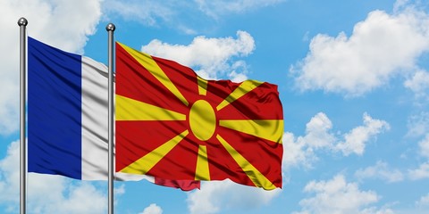 France and Macedonia flag waving in the wind against white cloudy blue sky together. Diplomacy concept, international relations.