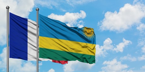 France and Rwanda flag waving in the wind against white cloudy blue sky together. Diplomacy concept, international relations.