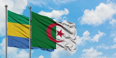 Gabon and Algeria flag waving in the wind against white cloudy blue sky together. Diplomacy...