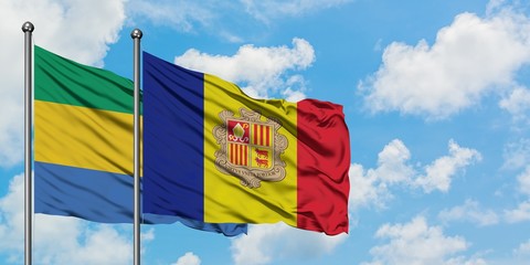 Gabon and Andorra flag waving in the wind against white cloudy blue sky together. Diplomacy...