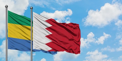 Gabon and Bahrain flag waving in the wind against white cloudy blue sky together. Diplomacy concept, international relations.