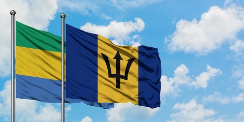 Gabon and Barbados flag waving in the wind against white cloudy blue sky together. Diplomacy concept, international relations.