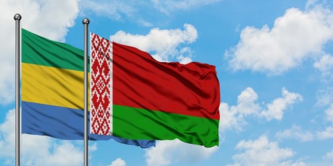 Gabon and Belarus flag waving in the wind against white cloudy blue sky together. Diplomacy concept, international relations.