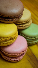 Colored macarons isolated on wooden dish, typical French dish