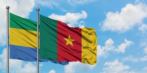 Gabon and Cameroon flag waving in the wind against white cloudy blue sky together. Diplomacy concept, international relations.