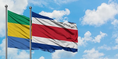 Gabon and Costa Rica flag waving in the wind against white cloudy blue sky together. Diplomacy concept, international relations.