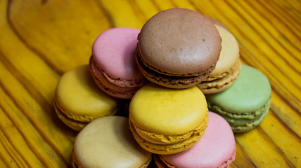 Colored macarons isolated on wooden dish, typical French dish