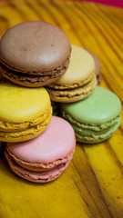 Colored macarons isolated on wooden dish, typical French dish