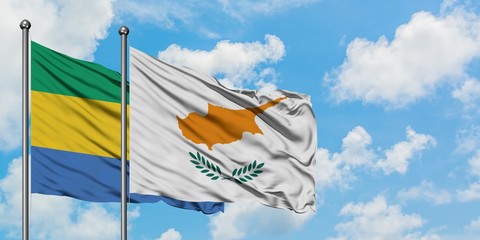 Gabon and Cyprus flag waving in the wind against white cloudy blue sky together. Diplomacy concept,...