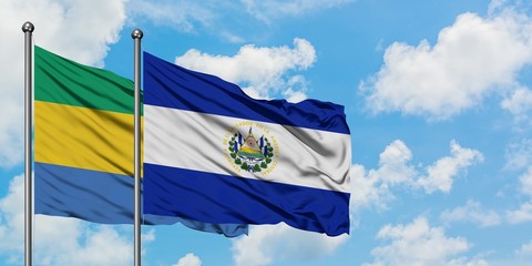 Gabon and El Salvador flag waving in the wind against white cloudy blue sky together. Diplomacy concept, international relations.