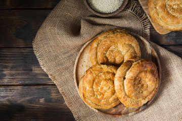 Buns on a wooden plate on a wooden table. Confectionery. Rustic style