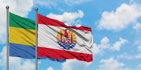 Gabon and French Polynesia flag waving in the wind against white cloudy blue sky together. Diplomacy concept, international relations.