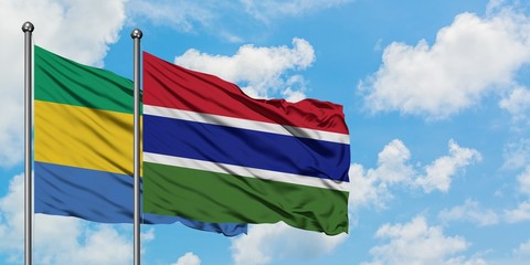 Gabon and Gambia flag waving in the wind against white cloudy blue sky together. Diplomacy concept, international relations.