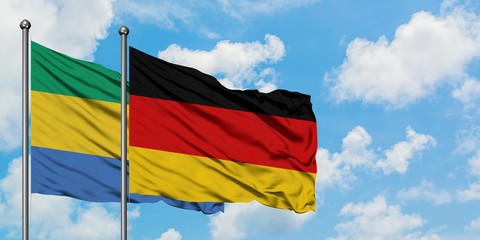 Gabon and Germany flag waving in the wind against white cloudy blue sky together. Diplomacy concept, international relations.