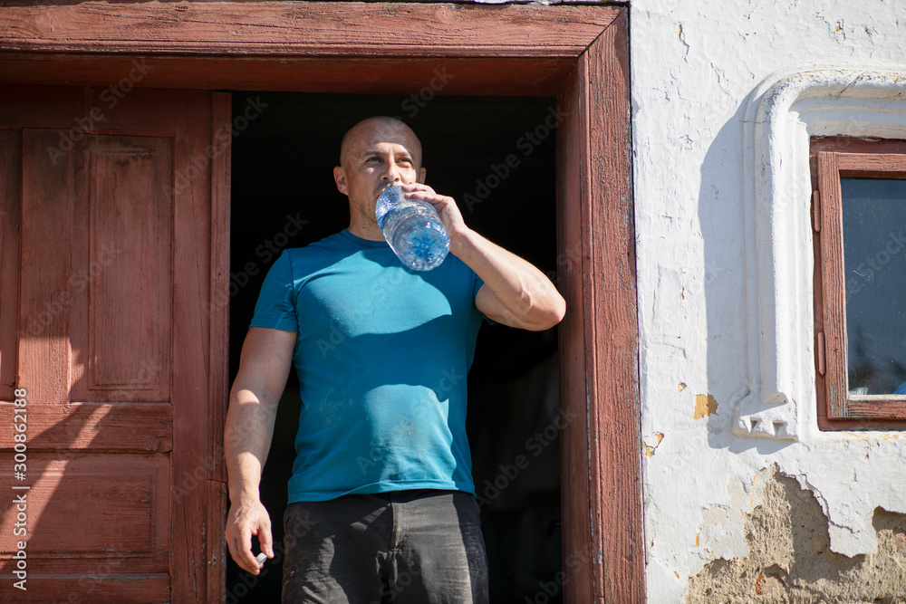 Wall mural Thirsty lumberjack drinking water and having a break